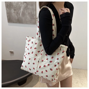 Détail du sac cabas en velours côtelé blanc avec imprimé fraise et bandoulière