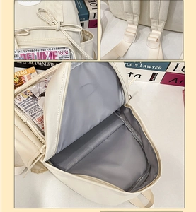 Detail of beige backpack showing bow decoration, inner lining and adjustable straps