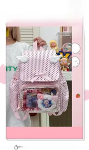 Detail view of pink polka dot ita bag with transparent display window and wings