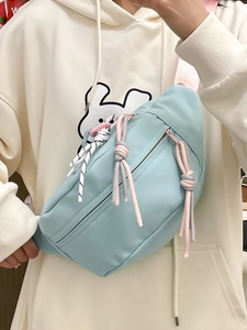 Detailansicht einer hellblauen Nylon-Brusttasche mit bunten geflochtenen Seildekorationen