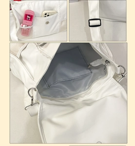 Detail view of the white crossbody ita bag showing multi-pocket storage and straps
