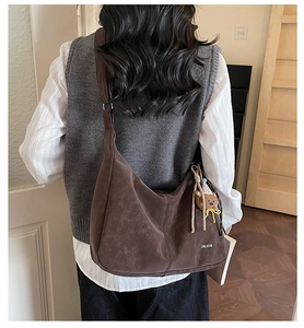 Grand sac croissant en similicuir marron avec texture douce porté par un modèle