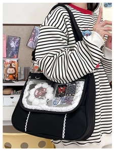Detail of black ita bag with clear window and white lace ruffles for anime badges