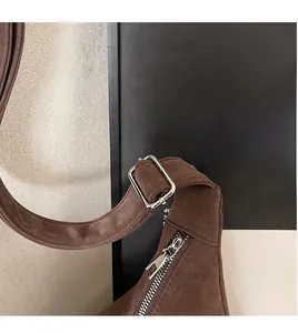Vue détaillée du sac en cuir marron foncé montrant la fermeture éclair et la bandoulière