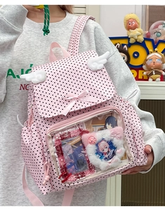 Detailed view of pink polka dot ita bag with transparent window and plush wings