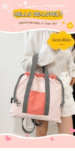 Detail view of pink nylon tote bag with orange pocket and grey textile shoulder straps