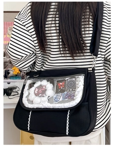 Detail of black ita bag featuring a lace-trimmed transparent window for badges and accessories