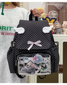 Detail view of black polka dot ita bag with transparent window for anime pins and wings