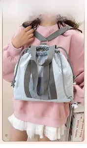 Detail view of the checkerboard drawstring closure on a light blue backpack