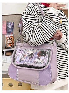 Detailed close-up of a purple Ita-bag featuring a transparent window with lace and bows