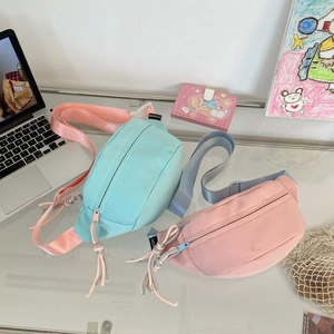 Detailansicht der mintgrünen und rosa Nylon-Brusttaschen mit dekorativen Knoten-Reißverschlüssen
