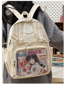 Detailed view of cream-colored ita bag with clear PVC pocket and cute ribbon accents