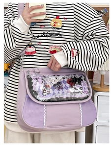 Detail view of purple ita bag with transparent window featuring lace and heart pin