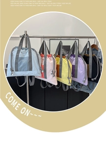 Detail of multi-color nylon drawstring backpacks in blue, pink, yellow, purple, and black