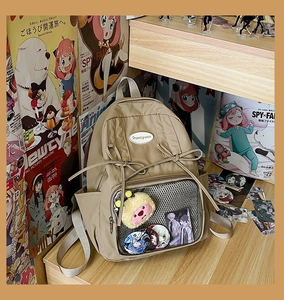 Detail of khaki ita bag with bow and clear window for anime badge display