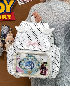 Detailed view of polka dot ita-bag featuring transparent window for badges and plush wings