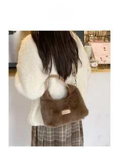 Brown faux fur shoulder bag with leather straps and gold plaque shown on model in cafe