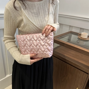 Roze gewatteerde handtas met hartpatroon vastgehouden door model in knusse kamer