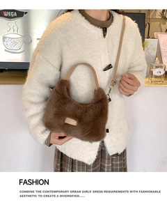 Close-up of dark brown plush handbag with faux fur texture and silver metal hardware details