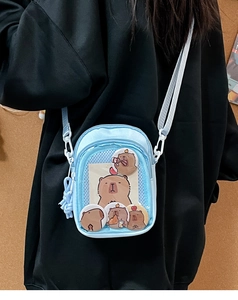 Detail of light blue ita bag showing transparent PVC window with capybara pins