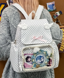 Polka dot backpack featuring a clear window display and white decorative wings