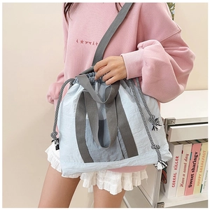 Light blue drawstring tote bag with woven rope detail and wide straps for daily commute