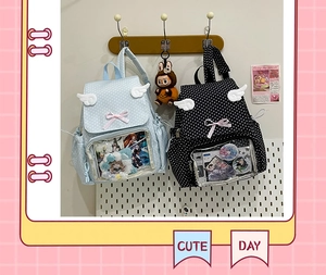 Close-up of cute polka dot ita bag with transparent window, wings, and ribbon details