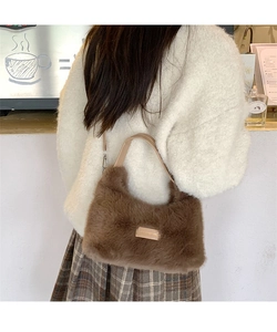 Detail of coffee plush faux fur handbag with metallic logo and leather strap