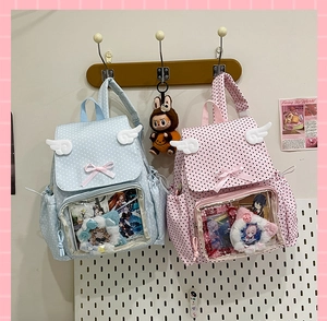 Detail of cute polka dot ita bag with transparent window and angel wings decoration