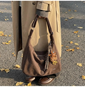 Détail du sac cabas en daim marron avec franges étoilées et pendentif ourson