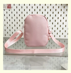 Detailed view of the pink mini crossbody bag with durable fabric and white plastic hooks