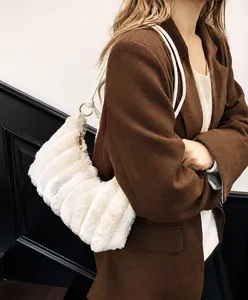 Close-up of fluffy cream plush texture and gold ring hardware on the faux fur shoulder bag