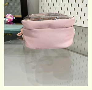 Detailed view of pink canvas ita bag featuring a clear PVC window for doll display