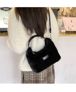 Detail of black plush handbag with love every day leather tag and gold lettering