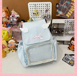 Detail of light blue polka dot ita bag with clear window, angel wings and pink bows
