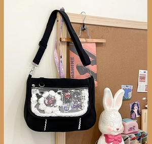 Detail of the black ita-bag featuring a transparent PVC window and side mesh pocket