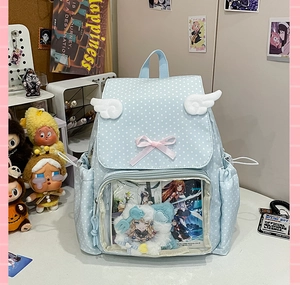 Detail of light blue polka dot ita bag with white angel wings and transparent PVC window