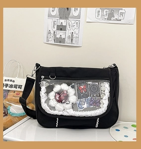 Close-up of black Ita bag with transparent PVC window featuring lace trim and anime badges