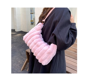 Detail of pink faux fur shoulder bag with wave texture worn over a black winter coat