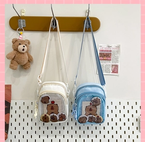 Detail view of small ita bags in beige and blue featuring clear display window and capybara pins