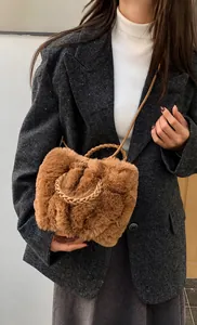 Close-up of camel plush handbag with woven handle and soft faux fur texture detail