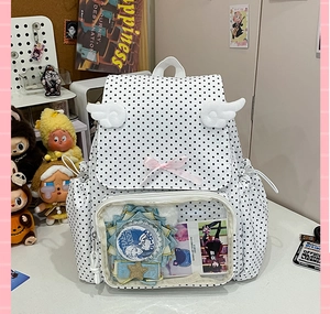 Detail view of ita bag window with polka dots, plush wings and anime badges