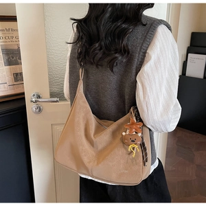 Détail du grand sac cabas vintage camel avec breloque ours et accessoire étoile