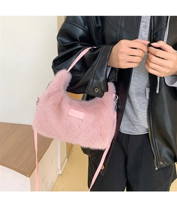 Detail view of the soft pink faux rabbit fur texture and matching leather logo tag on bag