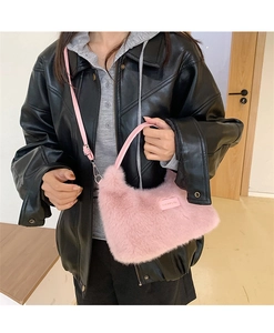 Detail of soft pink plush shoulder bag showing faux fur texture and leather strap buckle