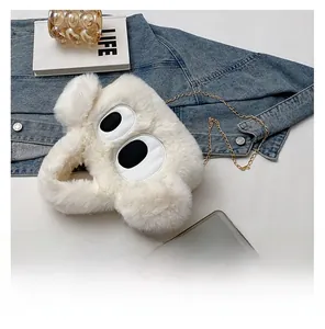 Détail du sac à main en peluche blanche avec broderie d'yeux et chaîne dorée