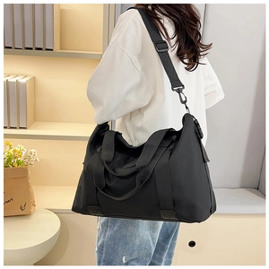 Detail of a black large capacity nylon travel bag with wide handles and metal swivel hooks