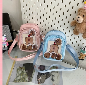 Detail of pink and blue Japanese style Ita bags with clear window and capybara badges