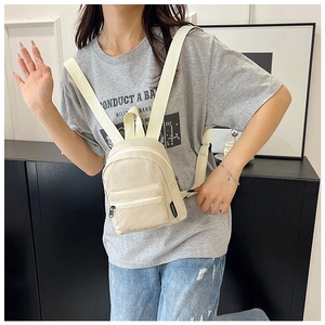 Detail view of mini nylon backpack in cream white with adjustable woven straps