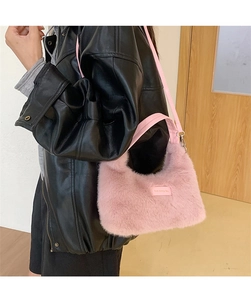 Detail of pink plush shoulder bag with 'love every day' leather patch and silver hardware